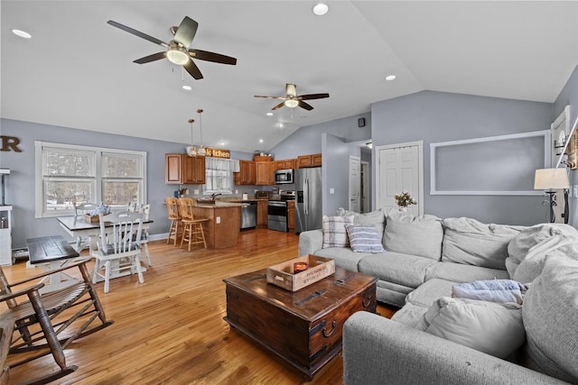 living area with baseboards, a ceiling fan, light wood-style flooring, vaulted ceiling, and recessed lighting