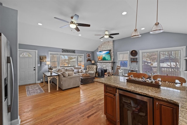 kitchen featuring a fireplace, lofted ceiling, recessed lighting, light wood-style flooring, and beverage cooler