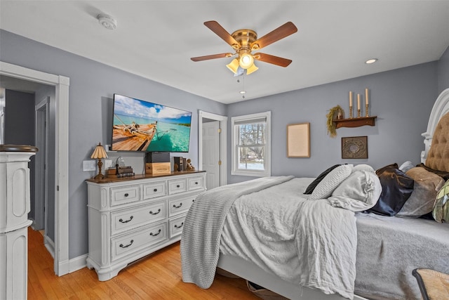 bedroom featuring light wood finished floors, a ceiling fan, and baseboards