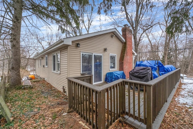 rear view of property featuring a deck and a chimney