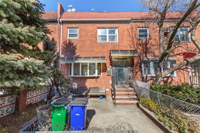 townhome / multi-family property featuring brick siding and fence