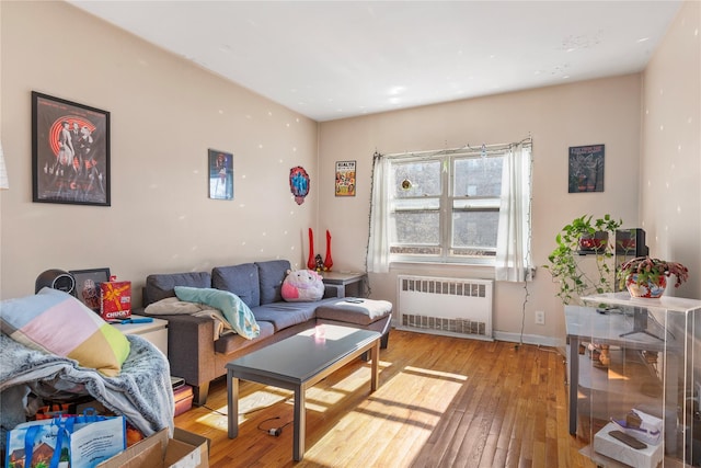 living room featuring light wood-type flooring, radiator, and baseboards