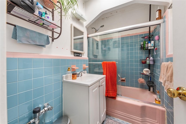 full bath featuring wainscoting, vanity, tile walls, and shower / bathtub combination