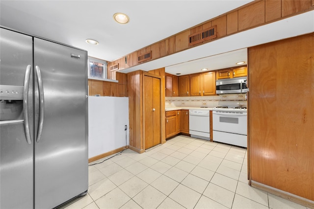 kitchen featuring brown cabinets, visible vents, stainless steel appliances, and light countertops