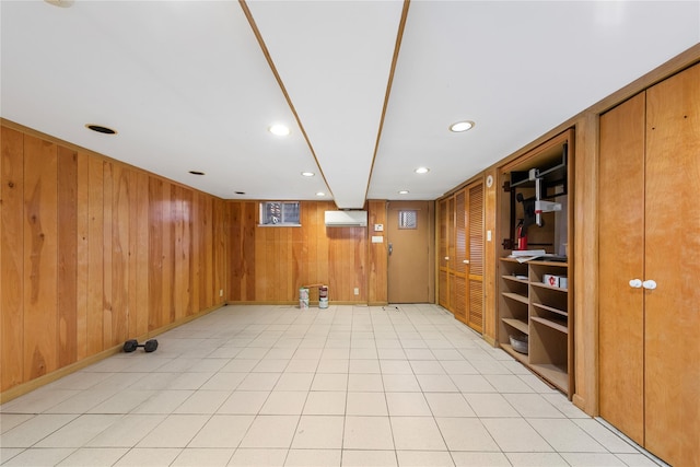 finished basement with baseboards, wood walls, a wall mounted air conditioner, and recessed lighting