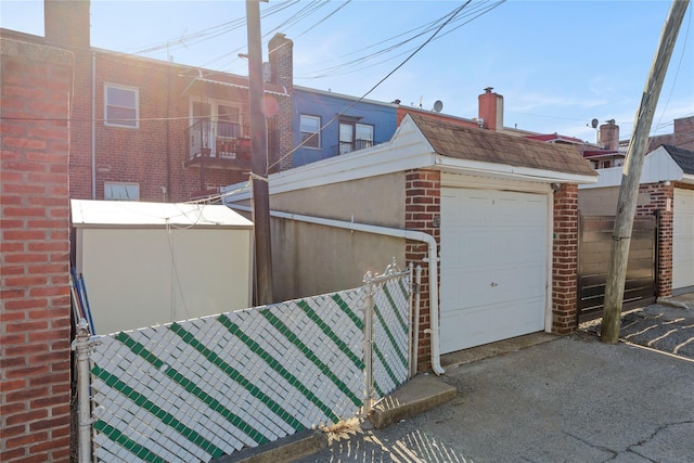 view of side of home featuring a garage, fence, and brick siding