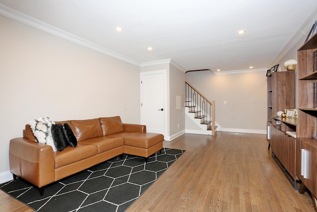 living room featuring baseboards, stairs, ornamental molding, and wood finished floors