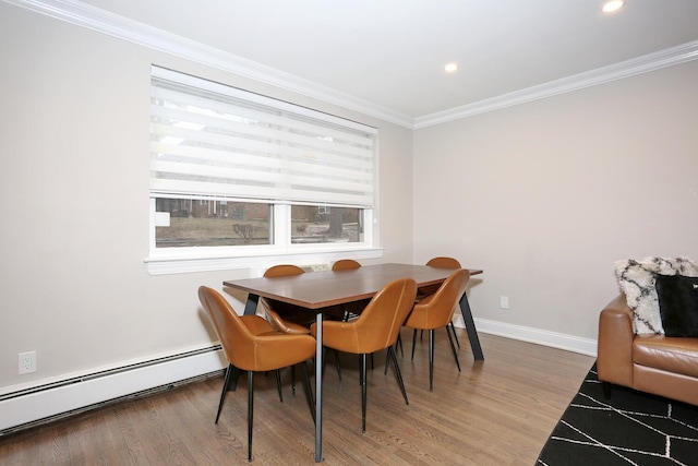 dining space with a baseboard heating unit, light wood-type flooring, baseboards, and crown molding