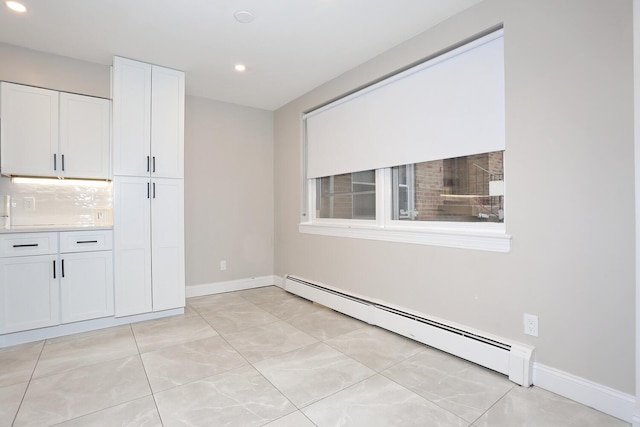 empty room with light tile patterned floors, a baseboard radiator, baseboards, and recessed lighting