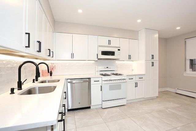 kitchen with white appliances, white cabinets, baseboard heating, light countertops, and a sink