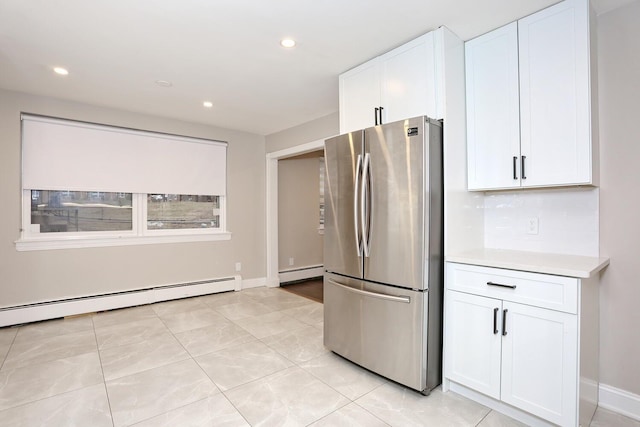 kitchen featuring a baseboard radiator, white cabinetry, light countertops, and freestanding refrigerator