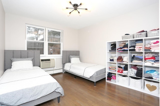 bedroom featuring baseboard heating, wood finished floors, and a wall mounted air conditioner