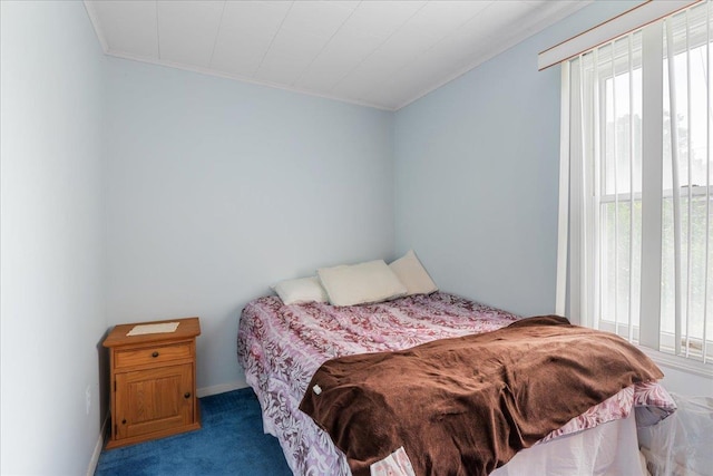 bedroom with ornamental molding and carpet flooring