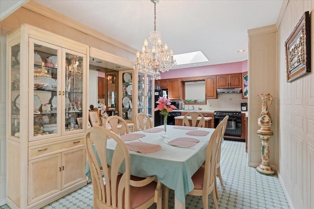 dining area featuring a chandelier and a skylight