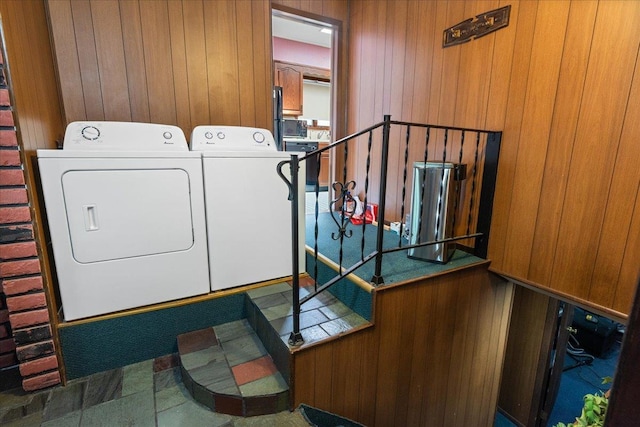 laundry room featuring washer and clothes dryer and wooden walls