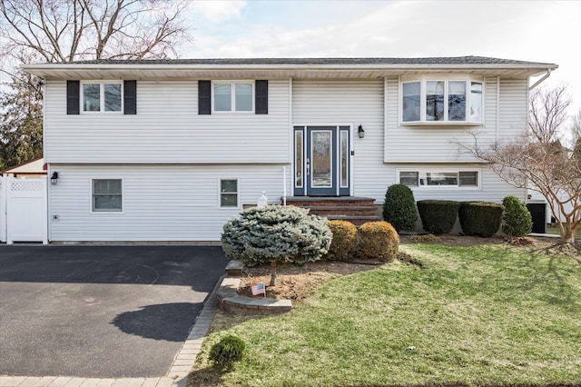 bi-level home featuring driveway and a front lawn