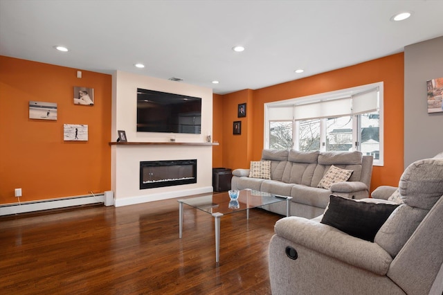 living area with visible vents, dark wood finished floors, a glass covered fireplace, a baseboard radiator, and recessed lighting