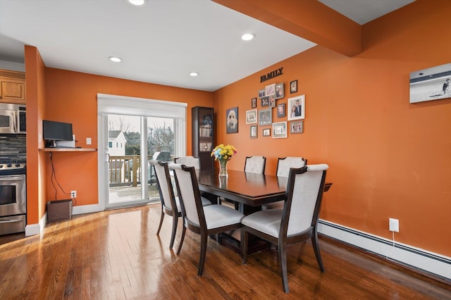 dining room with baseboards, baseboard heating, wood finished floors, and recessed lighting