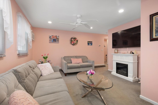 living area featuring recessed lighting, carpet floors, a ceiling fan, baseboards, and a glass covered fireplace