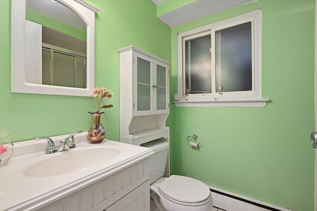 bathroom featuring toilet, a shower with door, a baseboard heating unit, and vanity