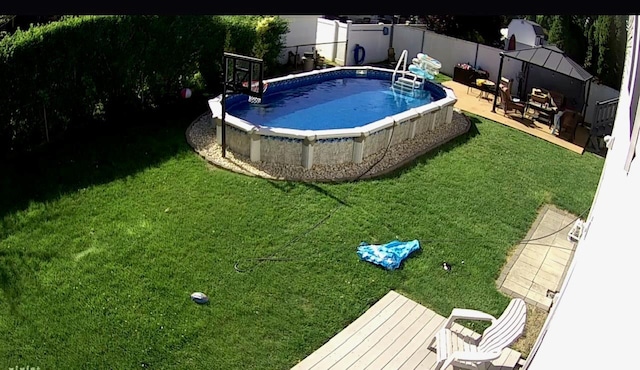 outdoor pool with a lawn and a fenced backyard