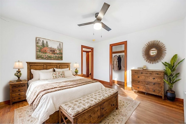 bedroom featuring ceiling fan, light wood-style flooring, and baseboards