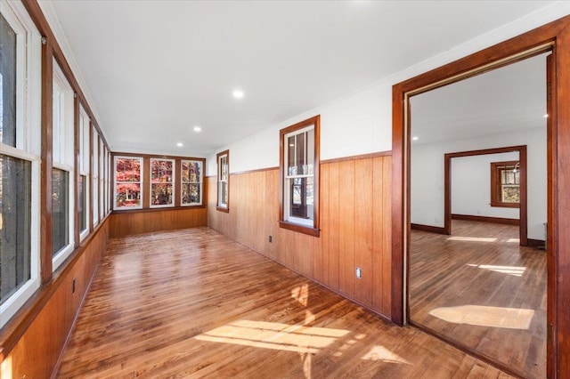 empty room featuring recessed lighting, wainscoting, wood finished floors, and wooden walls