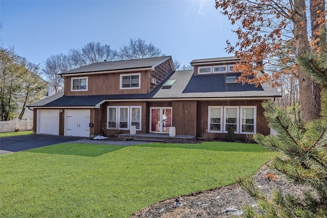 view of front of home featuring aphalt driveway, a shingled roof, fence, a garage, and a front lawn