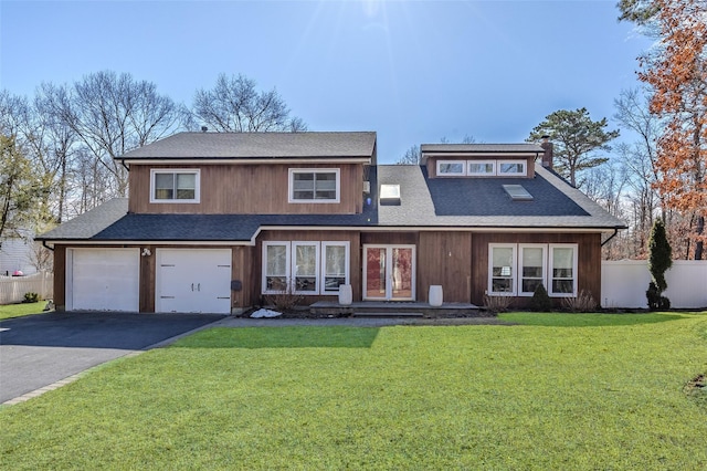 view of front facade featuring driveway, a garage, a shingled roof, fence, and a front yard