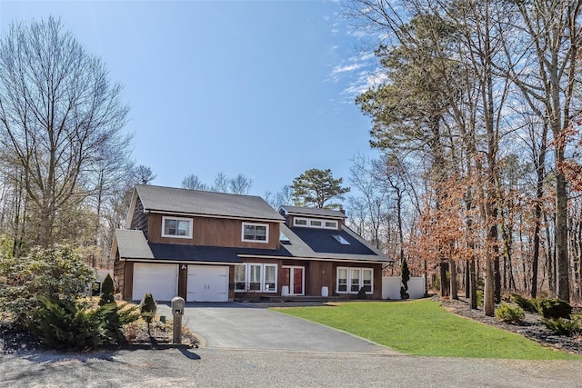 view of front of property featuring driveway, an attached garage, and a front lawn