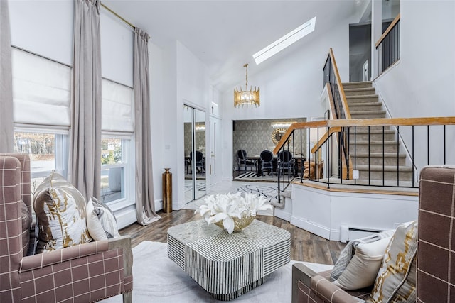 living area featuring stairs, wood finished floors, a baseboard radiator, and a chandelier