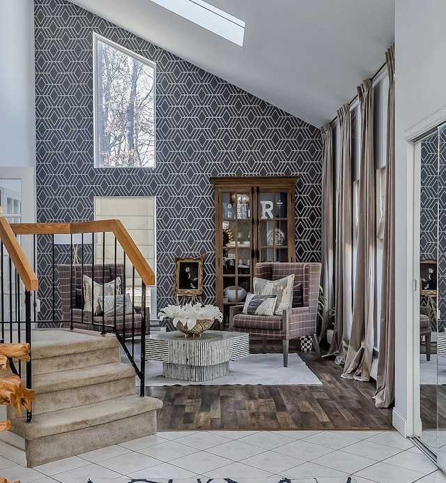 unfurnished room featuring vaulted ceiling with skylight, stairway, and tile patterned flooring