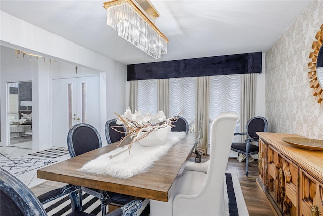 dining area featuring wood finished floors and an inviting chandelier