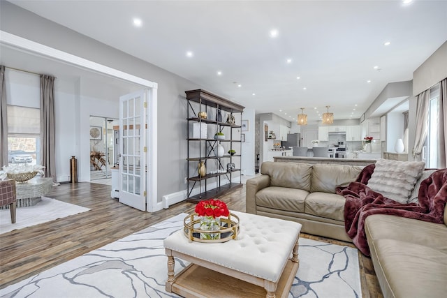 living area with light wood-type flooring, baseboards, and recessed lighting