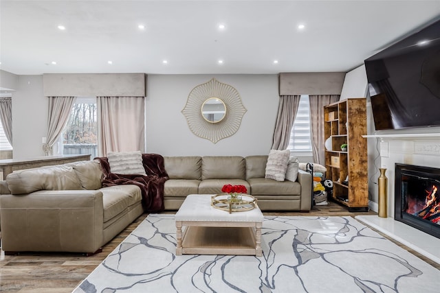 living area featuring a tile fireplace, light wood-style flooring, and recessed lighting