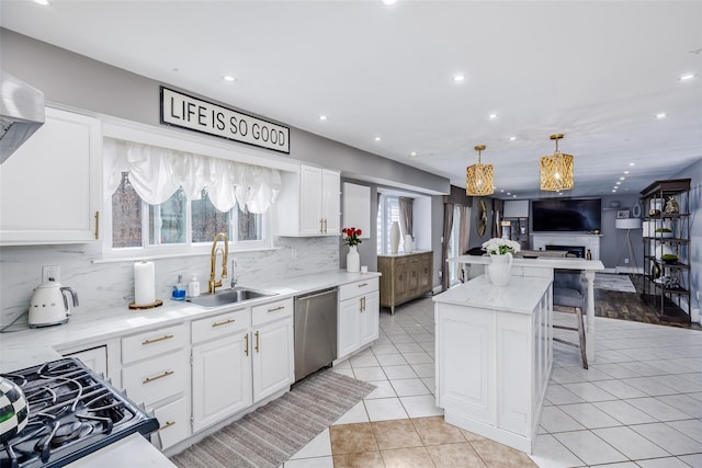 kitchen featuring range with gas cooktop, stainless steel dishwasher, open floor plan, light tile patterned flooring, and a sink