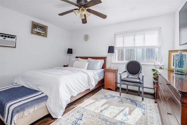 bedroom featuring a ceiling fan, baseboard heating, and wood finished floors