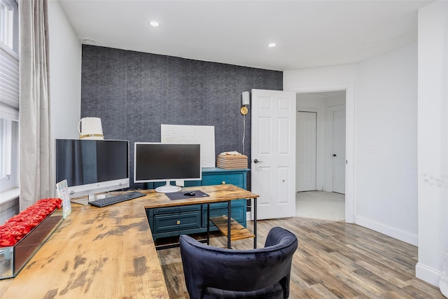 home office featuring recessed lighting, an accent wall, wood finished floors, baseboards, and wallpapered walls