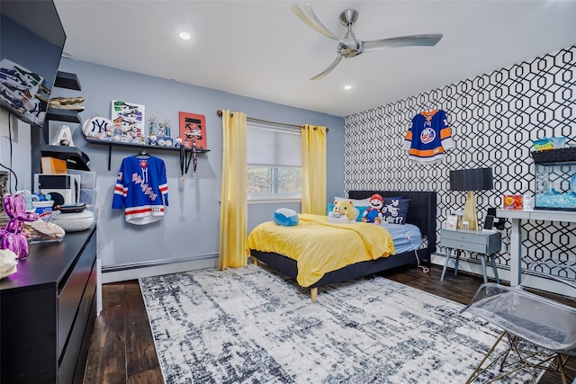 bedroom with an accent wall, recessed lighting, baseboard heating, and wood finished floors