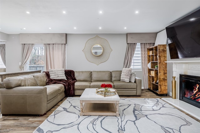 living area featuring light wood finished floors, a fireplace, and recessed lighting