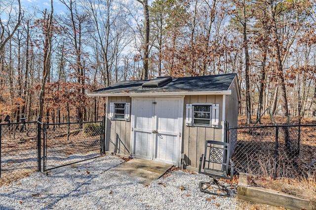 view of shed with fence and a gate