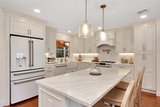 kitchen featuring dark wood-style floors, white appliances, a sink, and visible vents