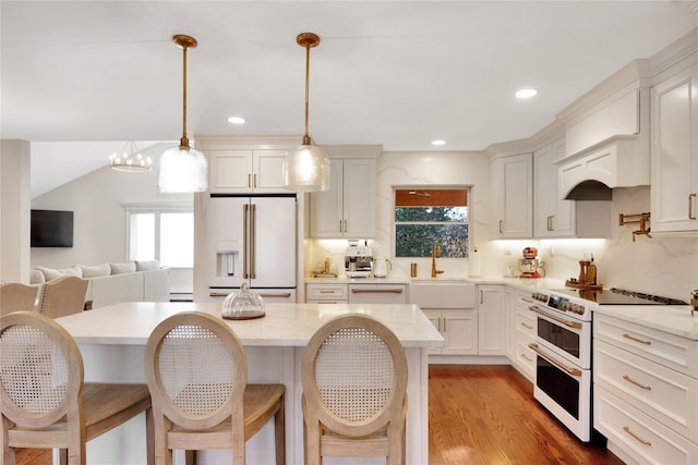 kitchen featuring a healthy amount of sunlight, white appliances, and a kitchen breakfast bar