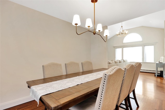 dining space with light wood-style flooring, an inviting chandelier, a baseboard heating unit, vaulted ceiling, and baseboards