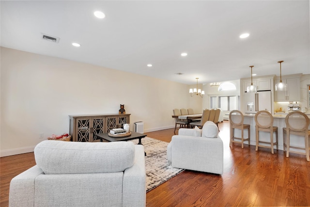 living room featuring baseboards, a chandelier, wood finished floors, and recessed lighting