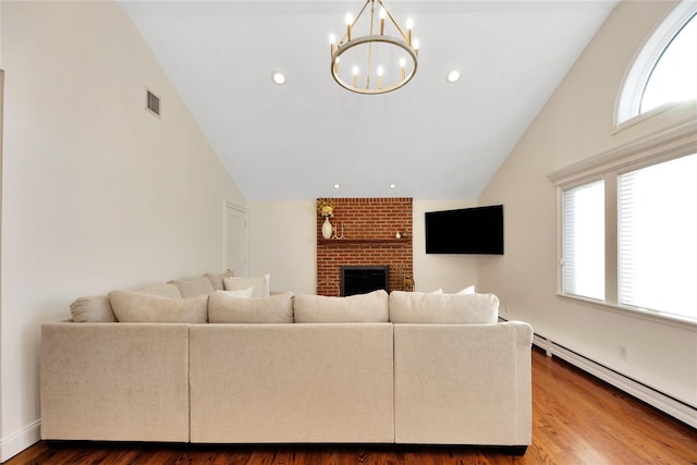 living area with a baseboard radiator, recessed lighting, wood finished floors, visible vents, and a brick fireplace