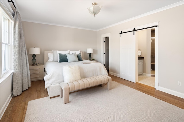 bedroom with a barn door, ornamental molding, and wood finished floors