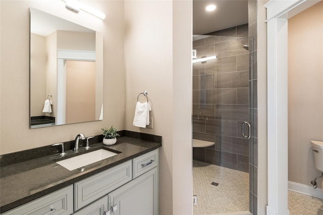 full bathroom with a stall shower, vanity, toilet, and baseboards