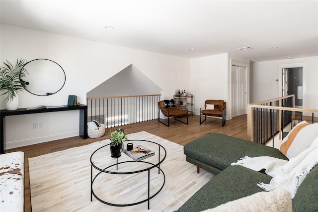 living room featuring baseboards, visible vents, and wood finished floors