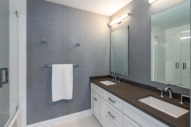 bathroom featuring double vanity, a sink, and baseboards